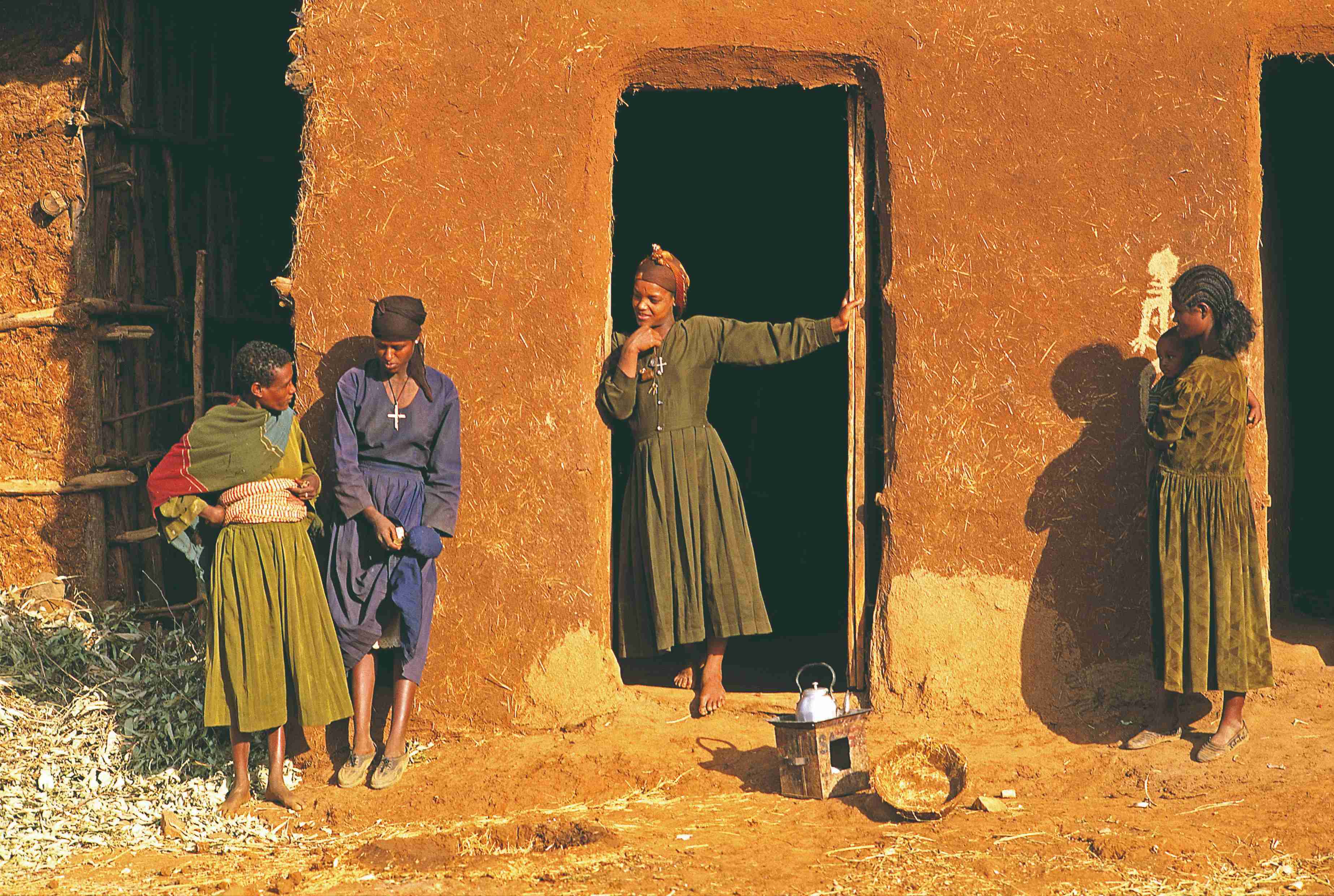 Femmes Amharas devant une maison traditionnelle.