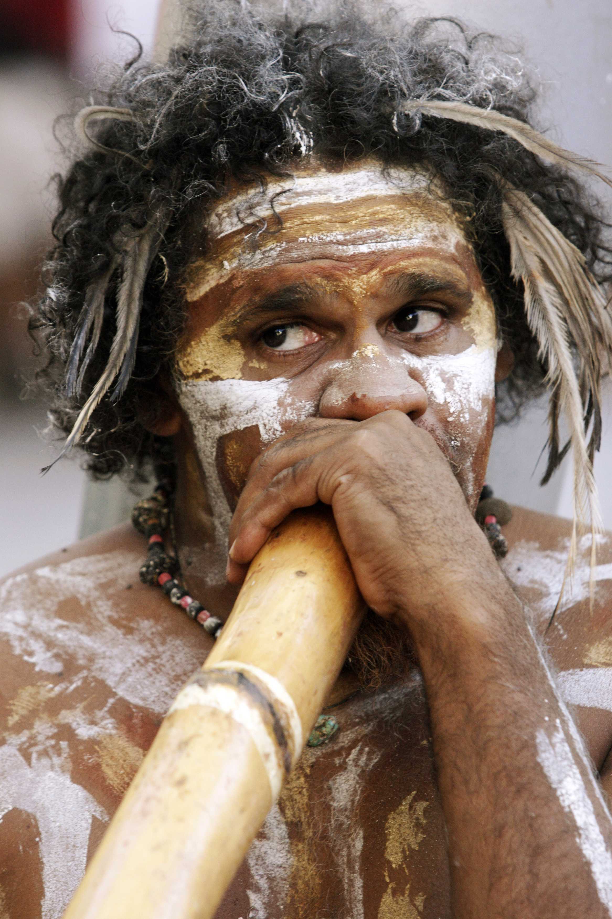 Homme aborigène jouant du didgeridoo.